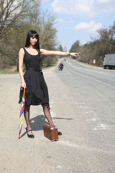 Girl with umbrella on the road — Stock Photo, Image