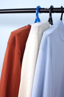 yastıklı askı bir raf üzerinde renkli kazak