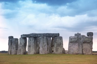 Stonehenge mavi gökyüzünün altında yeşil çimenlerin üzerinde tarihi bir site. stonehen