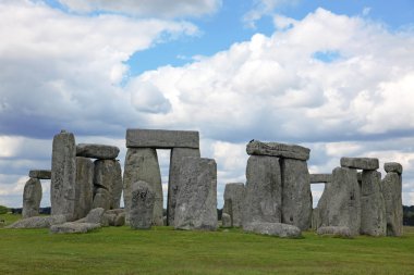Stonehenge mavi gökyüzünün altında yeşil çimenlerin üzerinde tarihi bir site. stonehen