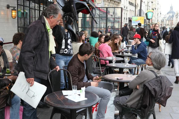 PARÍS - 27 DE ABRIL: Los parisinos y los turistas disfrutan de comidas y bebidas en la acera de la cafetería en París, Francia, el 27 de abril de 2013. París es una de las áreas metropolitanas más pobladas de Europa . —  Fotos de Stock