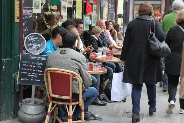 PARIS - 27 de abril: Parisienses e turistas gostam de comer e beber na calçada do café em Paris, França, em 27 de abril de 2013. Paris é uma das áreas metropolitanas mais povoadas da Europa . — Fotografia de Stock