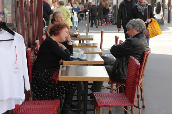 PARÍS - 27 DE ABRIL: Los parisinos y los turistas disfrutan de comidas y bebidas en la acera de la cafetería en París, Francia, el 27 de abril de 2013. París es una de las áreas metropolitanas más pobladas de Europa . — Foto de Stock