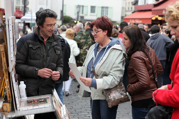 PARÍS - CIRCA 1 MAYO 2013: Pintor y comprador público en Montmartre — Foto de Stock