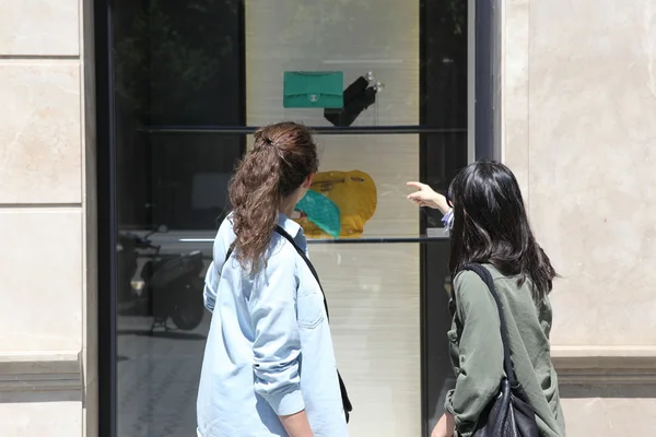 Zwei mädchen blicken auf das Schaufenster in barcelona — Stockfoto