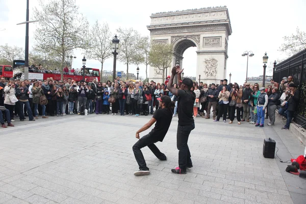 ПАРИЖ - 27 АПРЕЛЯ:: B-boy doing some breakdance moves in front a street crowd, at Arch of Triumph, April 27 2013, Paris, France — стоковое фото