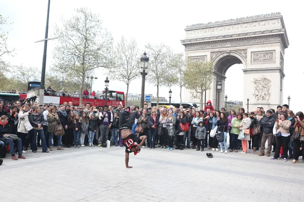 Paris - 27 april:: b-boy gör vissa breakdance rör sig framför en gatan folkmassa, arch av triumf, april 27 2013, paris, Frankrike — Stockfoto