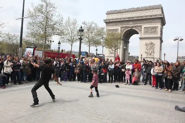 ПАРИЖ - 27 АПРЕЛЯ:: B-boy doing some breakdance moves in front a street crowd, at Arch of Triumph, April 27 2013, Paris, France — стоковое фото
