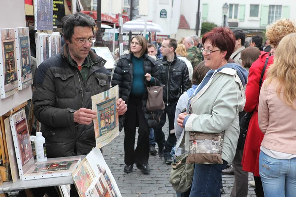 PARÍS - CIRCA 1 DE MAYO DE 2013: Pintor público y comprador en la colina de Montmartre en París alrededor del 1 de mayo de 2013 en París, Francia — Foto de Stock