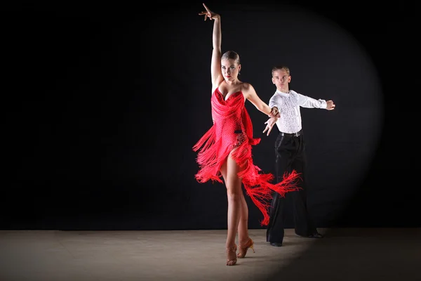 Bailarinos em salão contra fundo preto — Fotografia de Stock