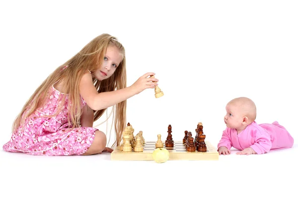 Adorable little two sisters 8 year and 3 month old play in chess — Stock Photo, Image