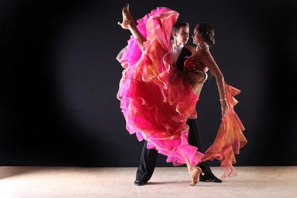 Латиноамериканські танцюристи в бальній кімнаті на чорному фоні — стокове фото