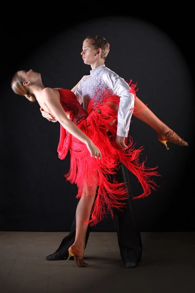 Latino dancers in ballroom against black background — Stock Photo, Image