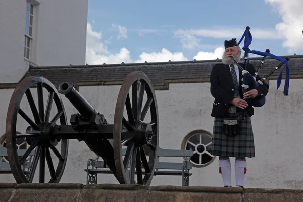 Unidentified Scoottish Bagpiper playing music with bagpipe