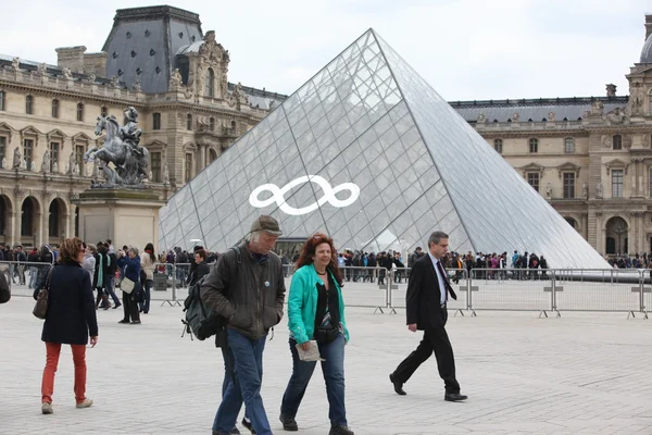 Люди ходят в знаменитый музей Лувра — стоковое фото
