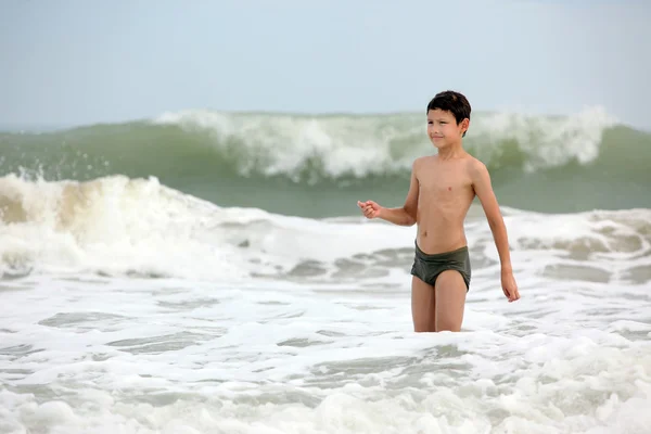 Menino em ondas no oceano — Fotografia de Stock