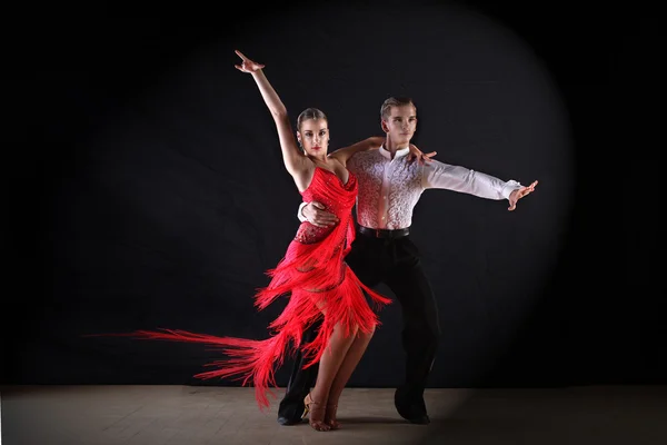 Dançarinos latinos no salão de baile contra fundo preto — Fotografia de Stock