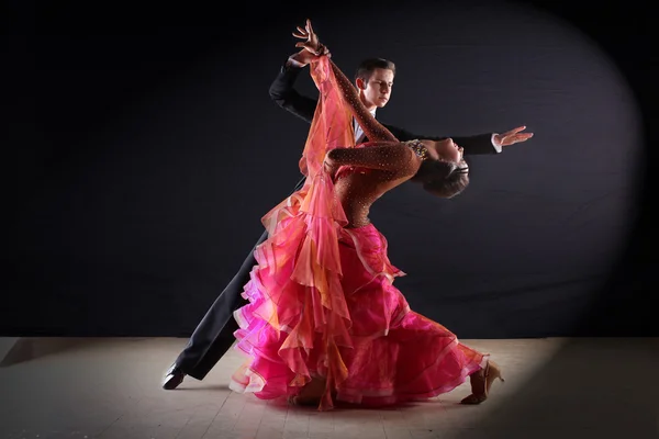 Latino dancers in ballroom against black background — Stock Photo, Image