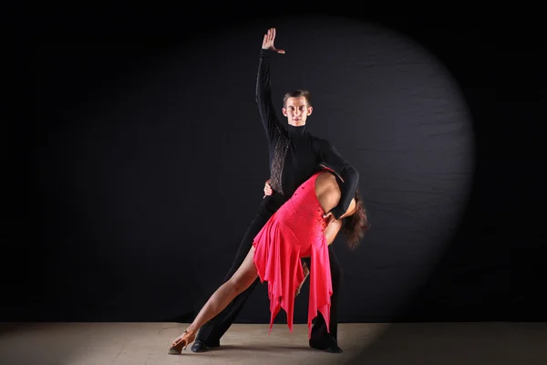 Latino dancers in ballroom against black background — Stock Photo, Image