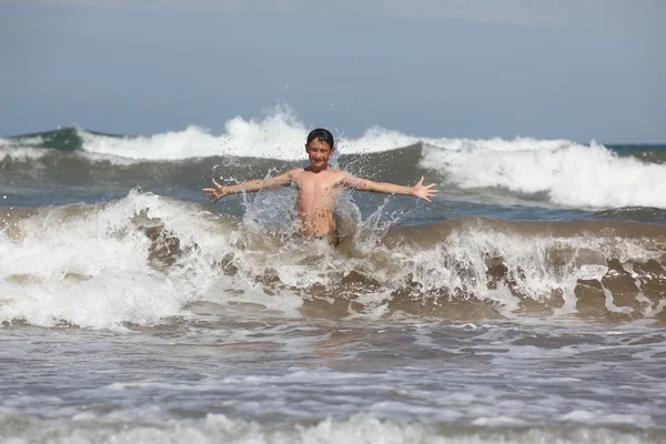 Boy play with ocean waves — Stock Photo, Image