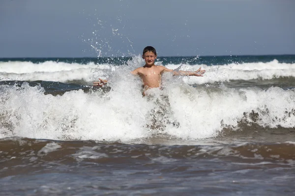 Garçon jouer avec océan vagues — Photo