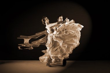 Balo salonundaki dansçılar siyah arkaplana karşı