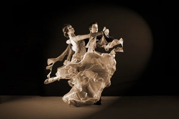 Bailarinos em salão contra fundo preto — Fotografia de Stock