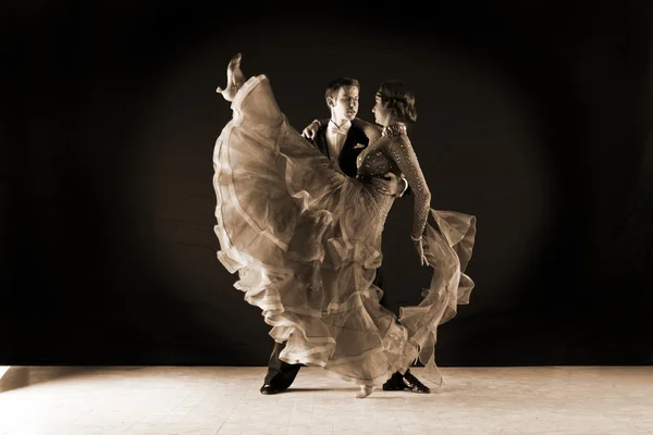 Bailarinos em salão contra fundo preto — Fotografia de Stock