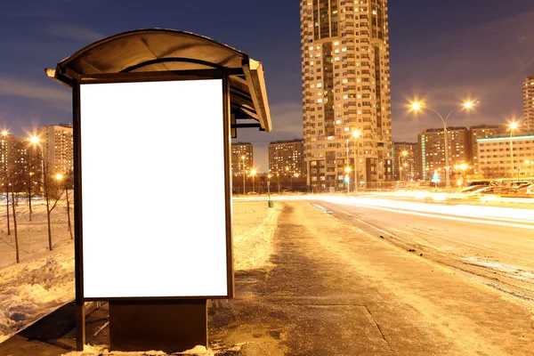 Blank sign at bus stop at evening in city — Stock Photo, Image