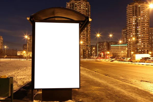 Blank sign at bus stop at evening in city — Stock Photo, Image