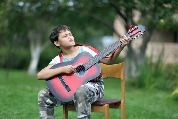 Il ragazzo sta suonando la chitarra — Foto Stock