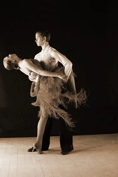 Bailarinos em salão contra fundo preto — Fotografia de Stock