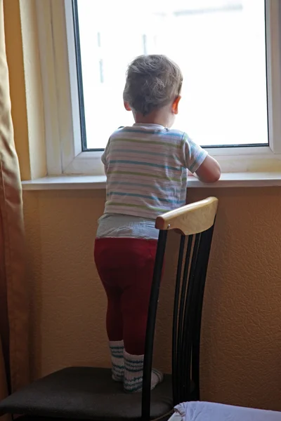 Yalnız küçük çocuk vitrinlere bakıyor — Stok fotoğraf