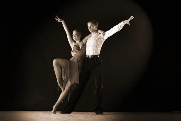 Dansers in balzaal tegen op zwart — Stockfoto