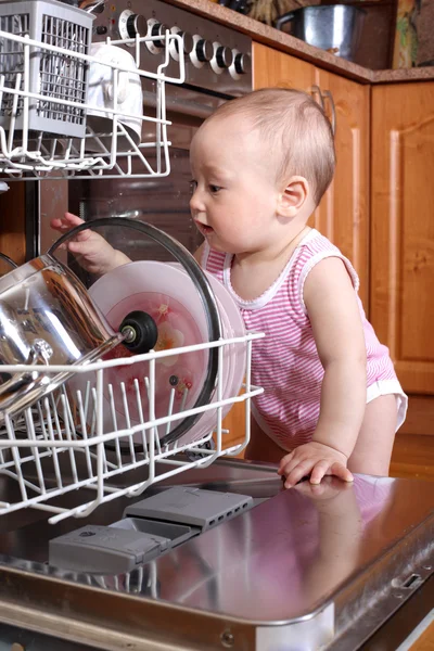 Child 1 year old in the kitchen at dishwasher — Stock Photo, Image
