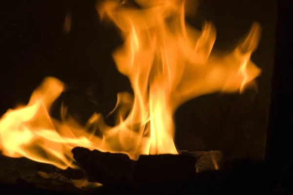 Bruciando e incandescente pezzi di legno nel camino — Foto Stock