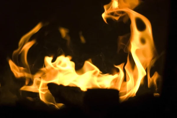 Hořící a svítící kusy dřeva v krbu — Stock fotografie