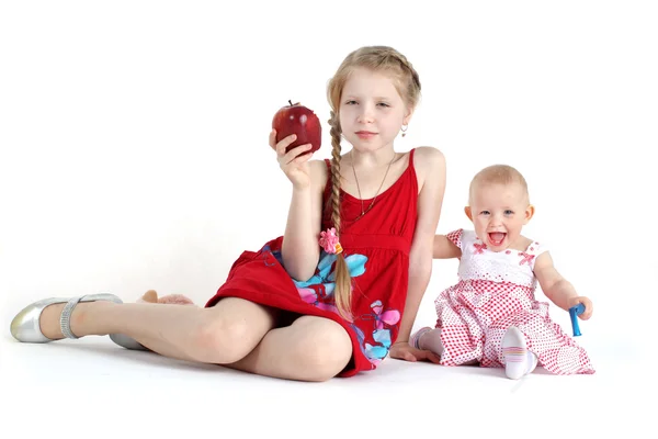 Bedårande lilla två systrar 8 år och 11 månader gammal med äpple — Stockfoto