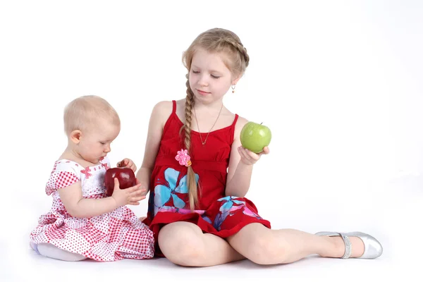 Bedårande lilla två systrar 8 år och 11 månader gammal med äpple — Stockfoto