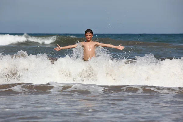 Garçon jouer avec océan vagues — Photo