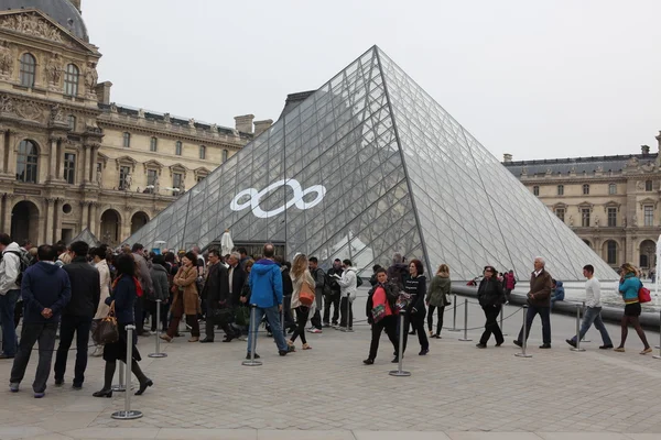 Люди ходят в знаменитый музей Лувра — стоковое фото