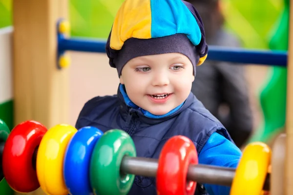 Jongen spelen op de speelplaats — Stockfoto