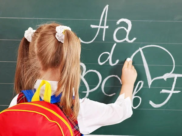 Schoolchild writing on blackboard — стоковое фото