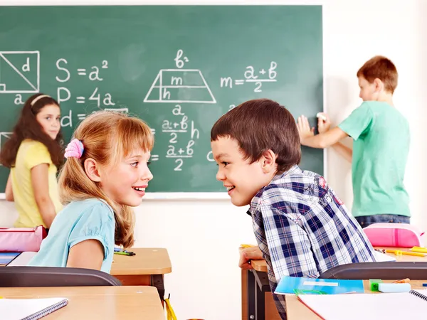 Skola barn skriver på tavlan. — Stockfoto