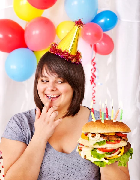 Woman eating hamburger at birthday. Royalty Free Stock Photos