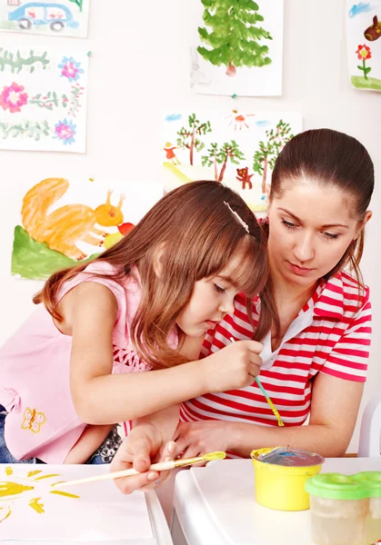 Petite fille peinture avec professeur à l'école maternelle . — Photo