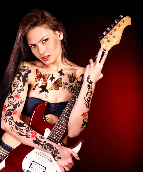 Girl with tattoo playing guitar. — Stock Photo, Image