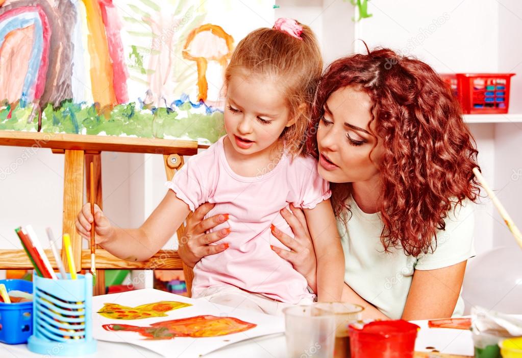 Child painting with mum.