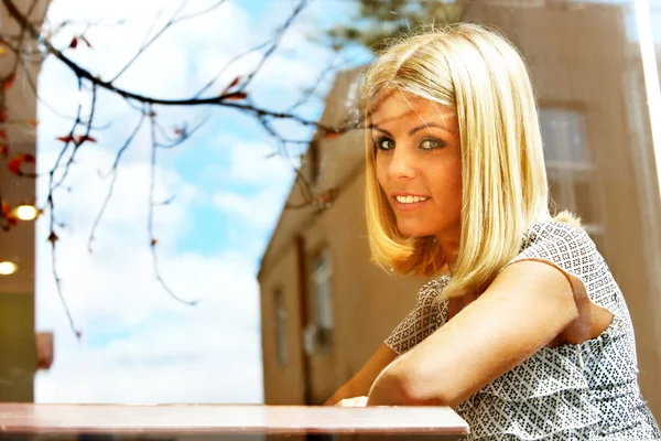 Vrouw kijkt uit raam in café . — Stockfoto