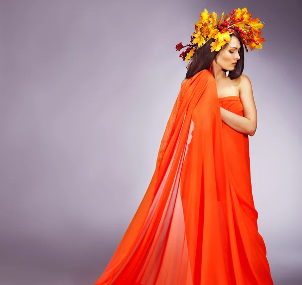 Niña con una corona de hojas de otoño en la cabeza . —  Fotos de Stock